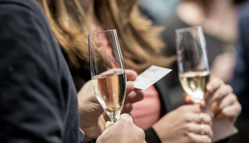 two people holding glasses of champagne at a networking event