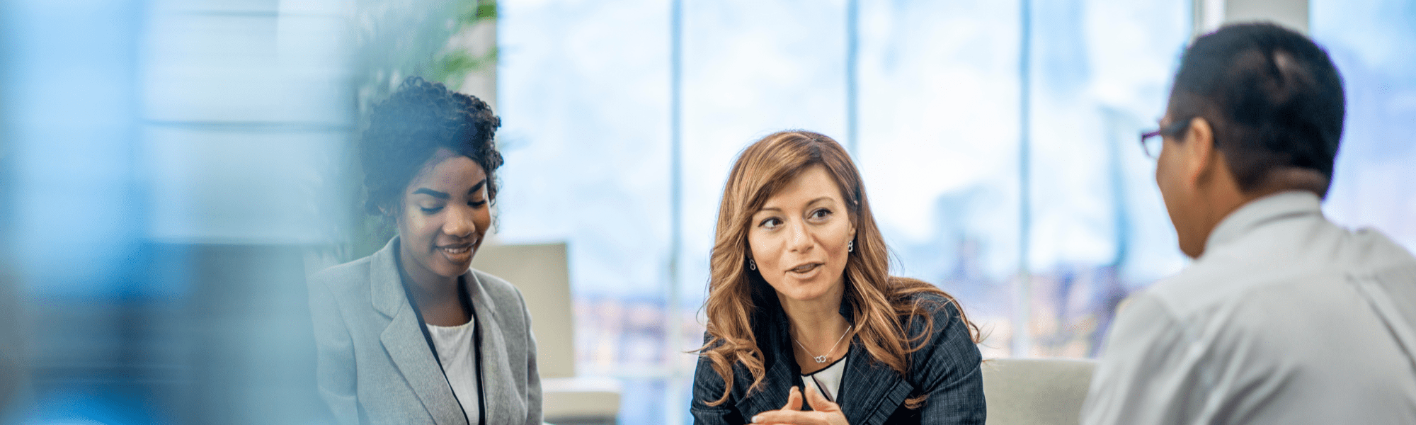 Woman seated at a low table talking to a man on her left